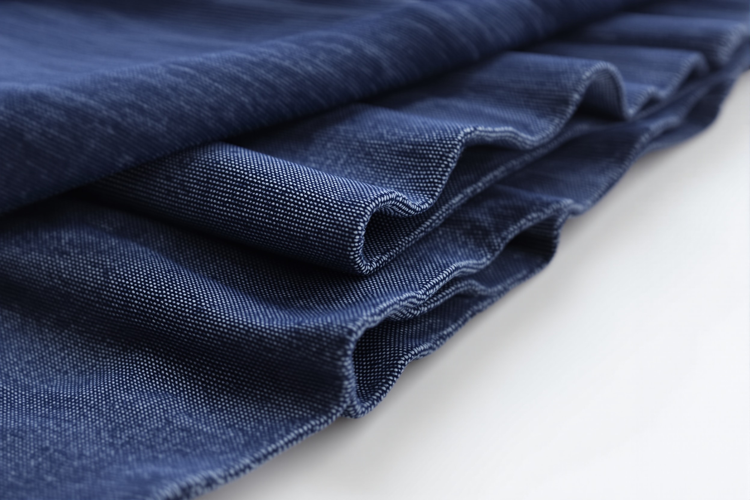 Close view of the seven crisp vertical pleats of a folded indigo hakama